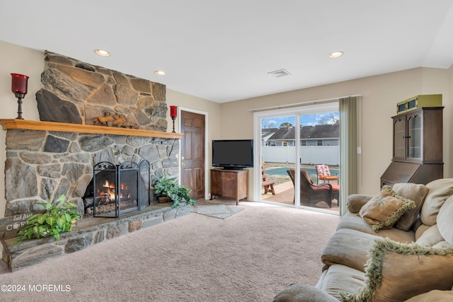 carpeted living room featuring a stone fireplace