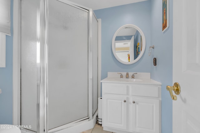 bathroom with tile patterned flooring, vanity, and a shower with shower door