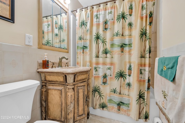 bathroom featuring walk in shower, vanity, tile walls, and toilet