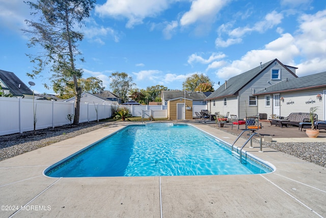 view of pool featuring a shed and a patio area