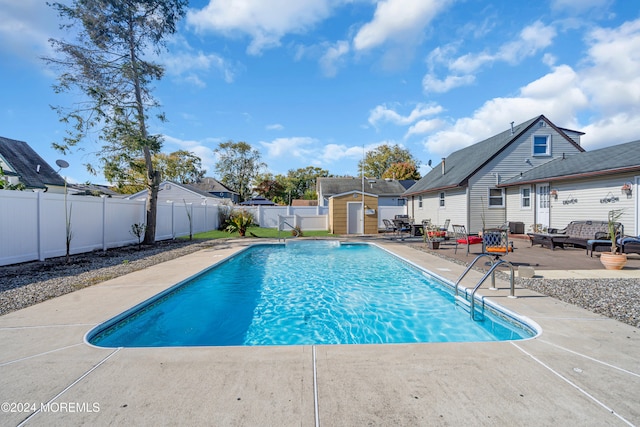 view of pool with a patio and a shed