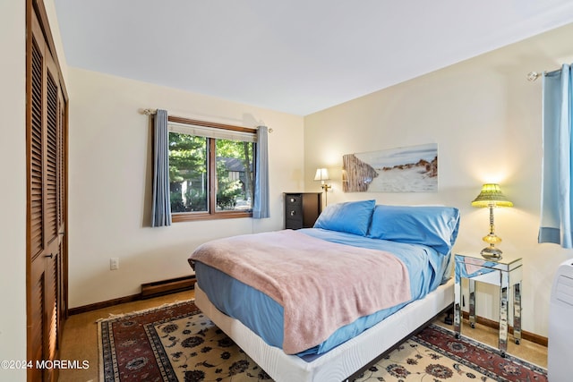 bedroom featuring a closet, carpet flooring, and a baseboard heating unit