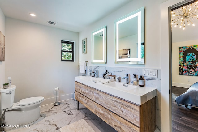 bathroom featuring a chandelier, toilet, backsplash, hardwood / wood-style flooring, and vanity