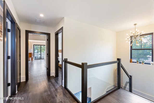 corridor featuring a notable chandelier and dark hardwood / wood-style flooring