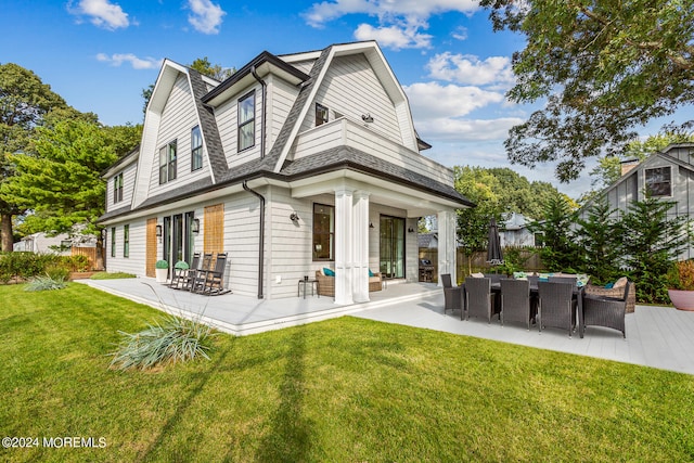 rear view of property featuring a yard and a patio area