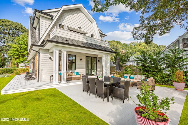 rear view of property featuring an outdoor hangout area, a wooden deck, and a yard