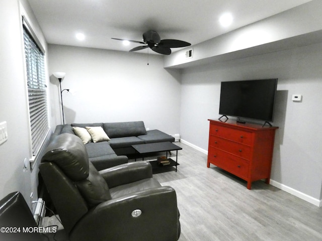 living room with light hardwood / wood-style floors and ceiling fan