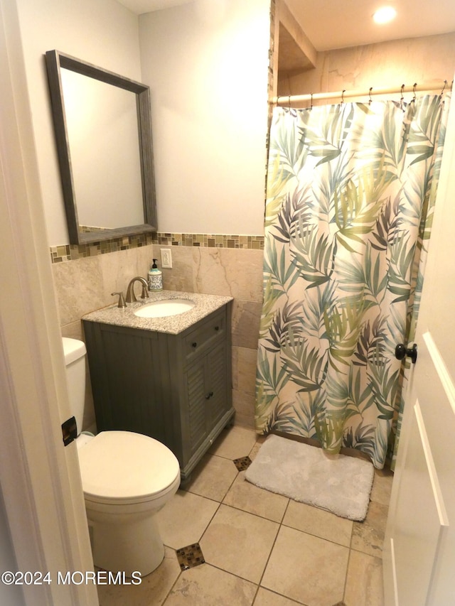 bathroom featuring tile walls, vanity, tile patterned floors, and toilet