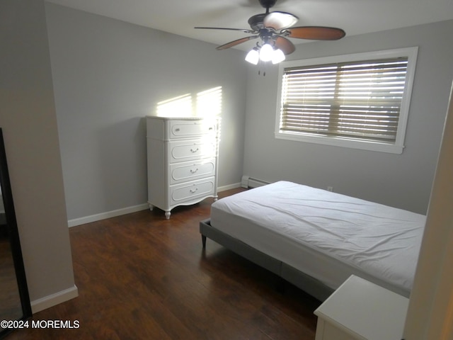 bedroom featuring dark wood-type flooring, ceiling fan, and a baseboard heating unit