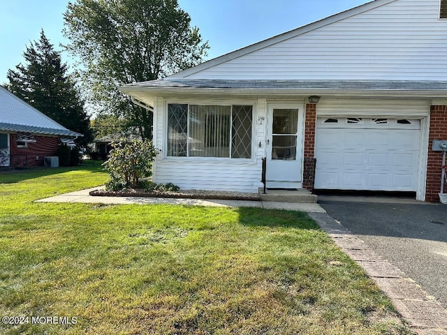 view of front facade featuring cooling unit, a front yard, and a garage