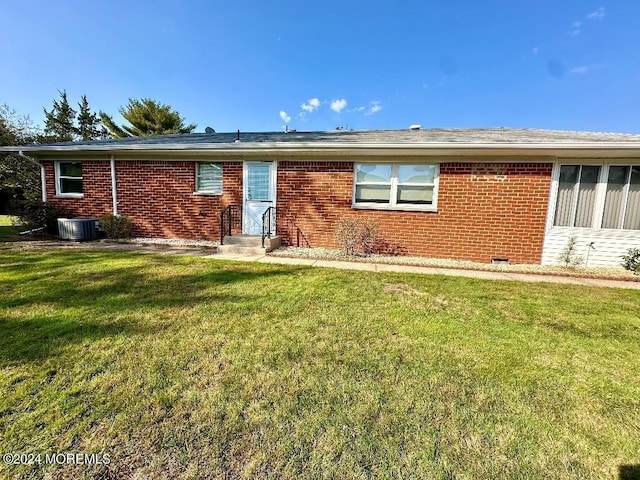 exterior space with a front lawn and central AC unit