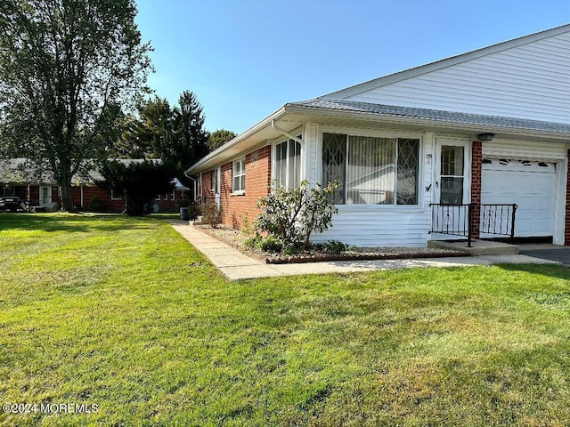 view of home's exterior with a garage and a lawn