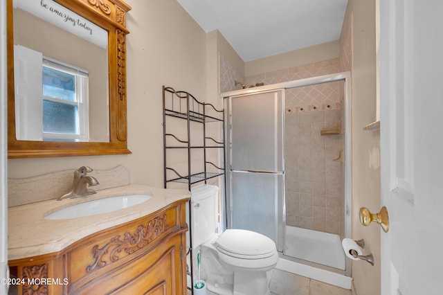 bathroom featuring vanity, tile patterned floors, a shower with door, and toilet