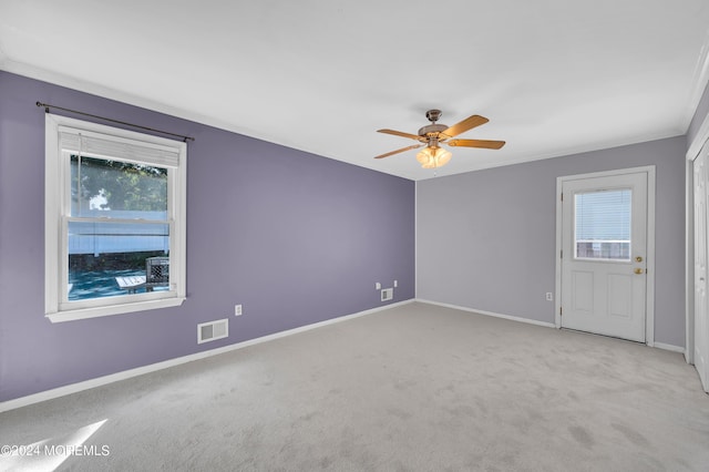 unfurnished room with ceiling fan, ornamental molding, and light carpet