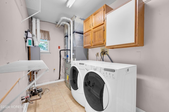 laundry area featuring cabinets, washer and dryer, and light tile patterned floors