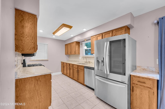 kitchen with tasteful backsplash, light tile patterned flooring, appliances with stainless steel finishes, and sink