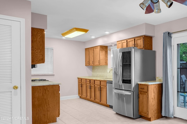 kitchen featuring stainless steel appliances, tasteful backsplash, sink, and ceiling fan