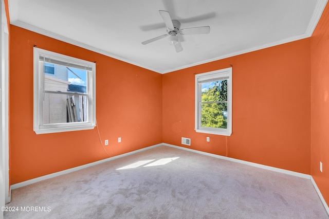 spare room featuring crown molding, light carpet, and ceiling fan