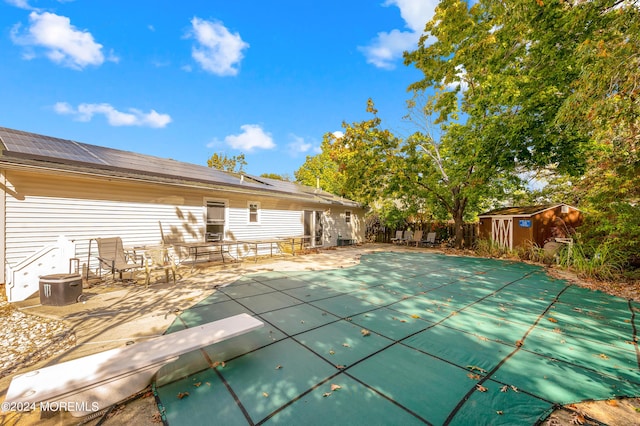 view of pool with a storage shed and a patio