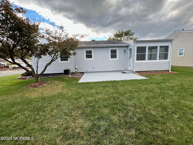 back of property with a patio area, central AC unit, and a yard