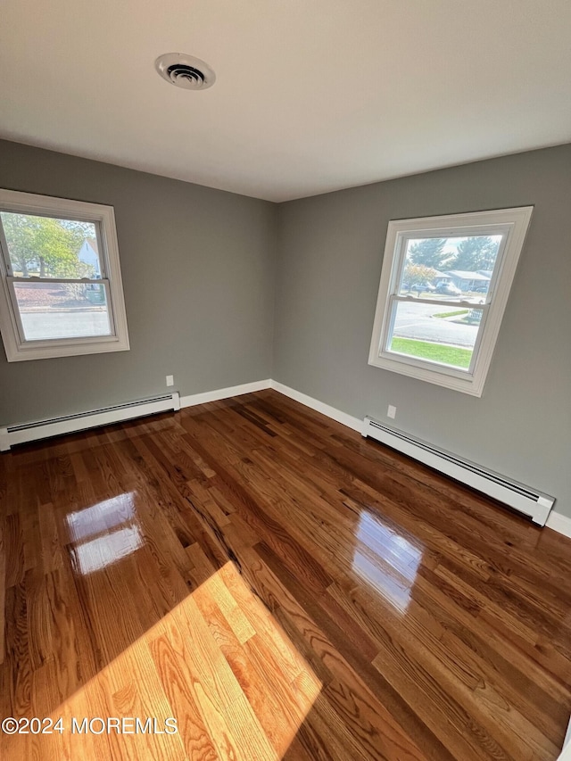 empty room with a baseboard radiator, visible vents, and a healthy amount of sunlight