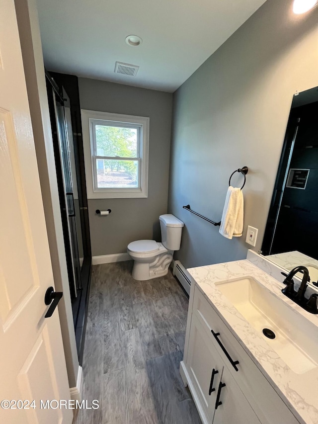 full bath featuring visible vents, toilet, a baseboard radiator, wood finished floors, and vanity