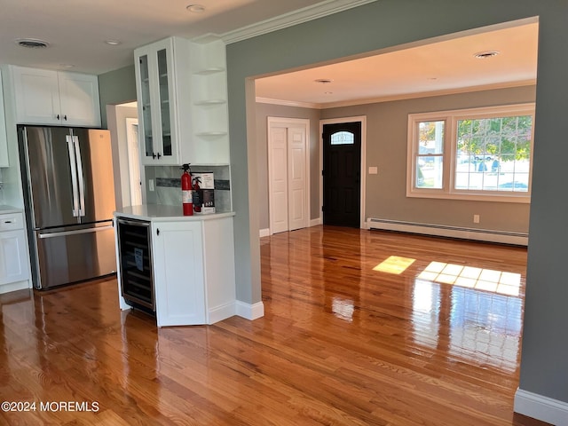 kitchen featuring white cabinets, wine cooler, baseboard heating, stainless steel refrigerator, and light wood-type flooring