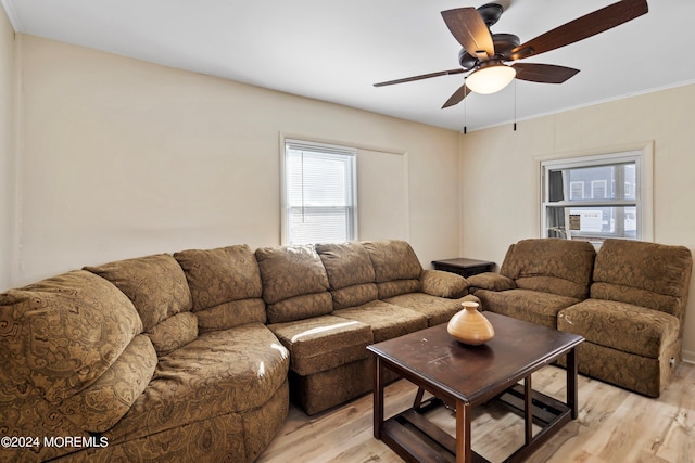 living room with crown molding, light wood-type flooring, and ceiling fan