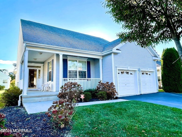 view of front facade featuring a porch, a front yard, and a garage