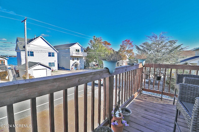 wooden terrace featuring a water view and a garage