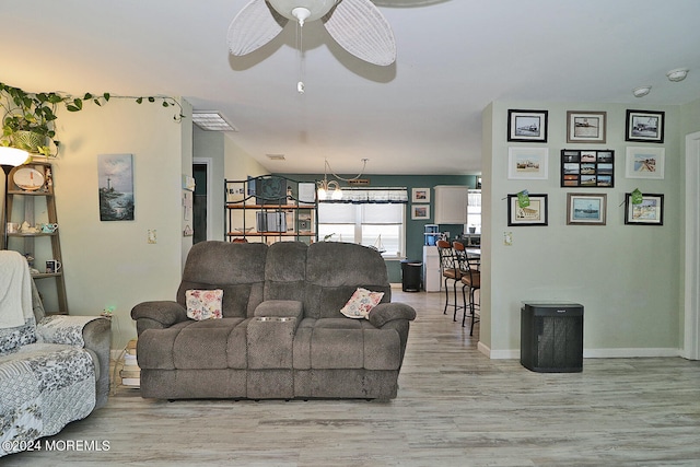 living room with ceiling fan and light hardwood / wood-style flooring