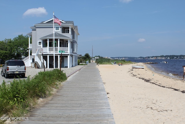 view of front of property featuring a water view and a beach view