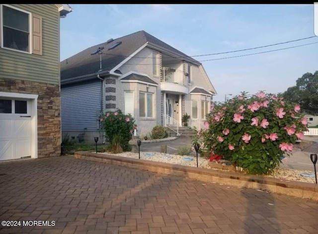 view of side of home with a balcony and a garage