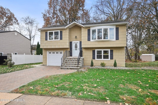 bi-level home featuring a garage and a front yard