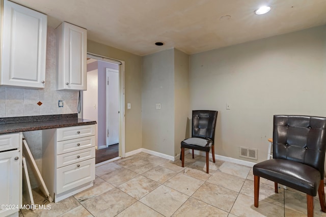 kitchen featuring white cabinets and backsplash