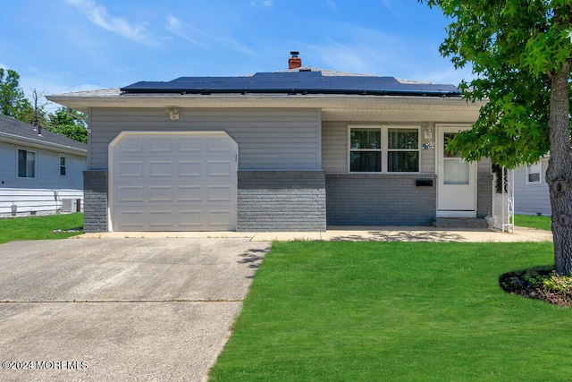 ranch-style house featuring solar panels, a front lawn, and a garage