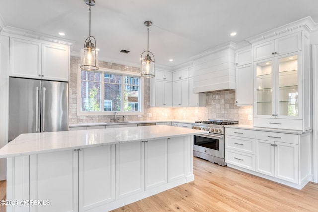 kitchen featuring a center island, high end appliances, and white cabinets