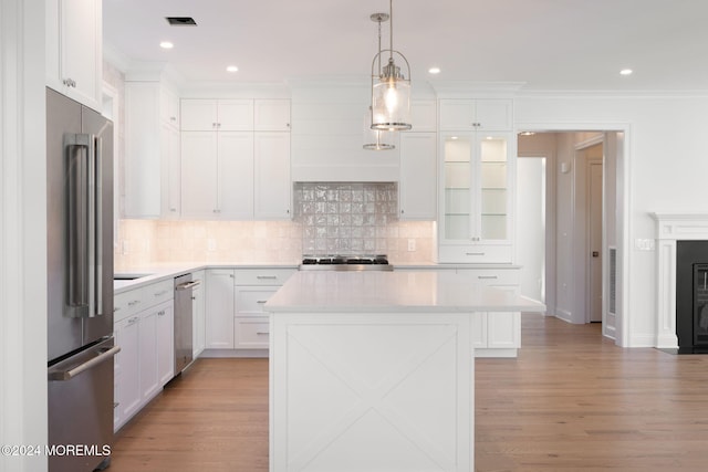 kitchen with appliances with stainless steel finishes, tasteful backsplash, light countertops, white cabinetry, and recessed lighting