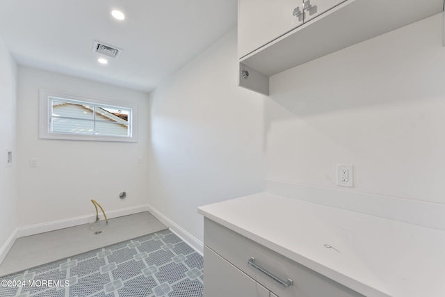 clothes washing area featuring baseboards and recessed lighting