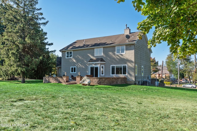 rear view of property with a lawn