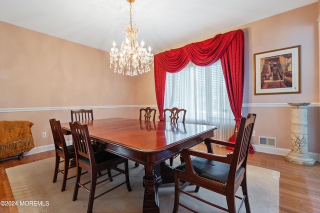 dining room with light hardwood / wood-style floors and an inviting chandelier