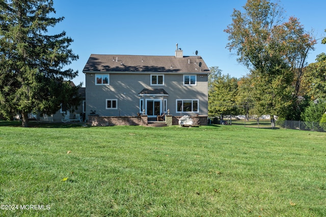 rear view of property with a yard