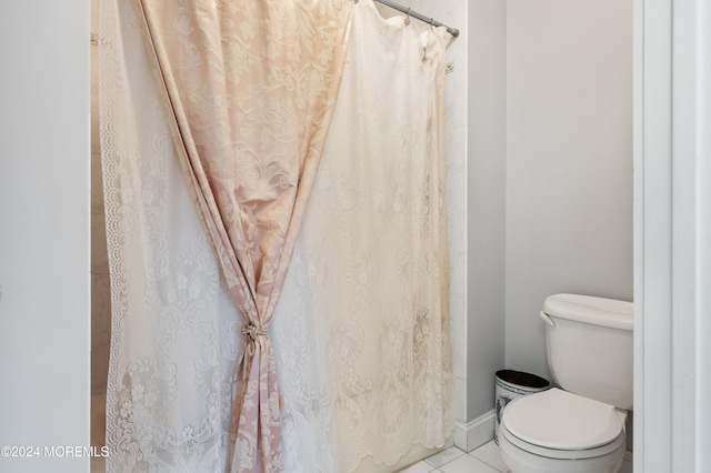 bathroom featuring a shower with curtain, toilet, and tile patterned flooring