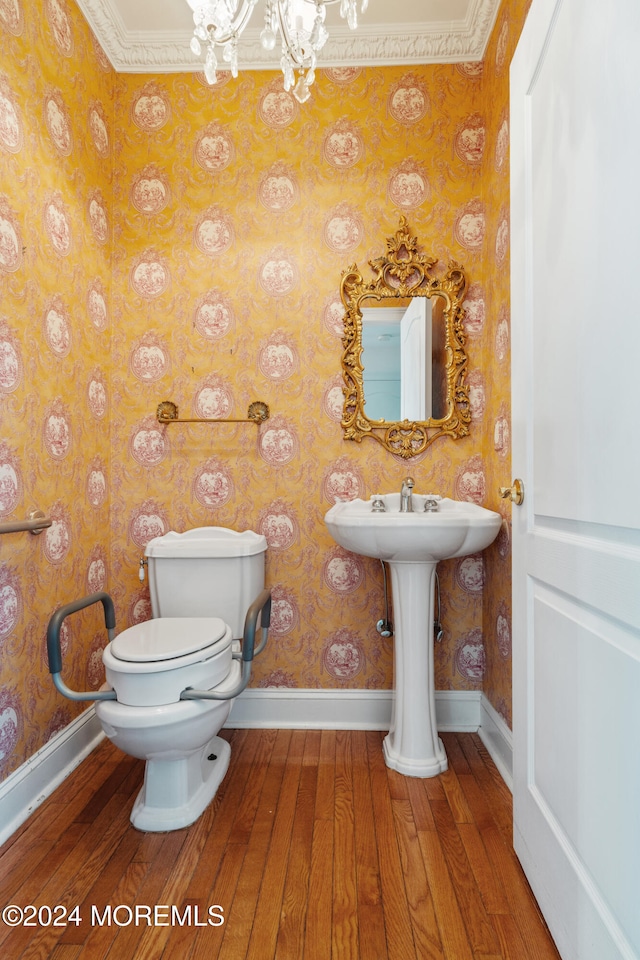 bathroom with toilet, hardwood / wood-style floors, a chandelier, and ornamental molding