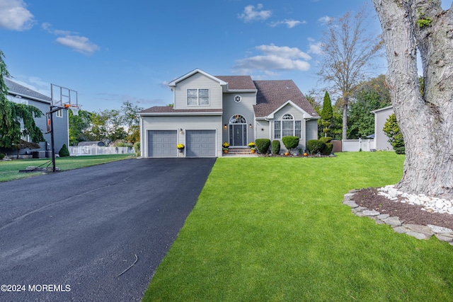 view of property with a garage and a front lawn