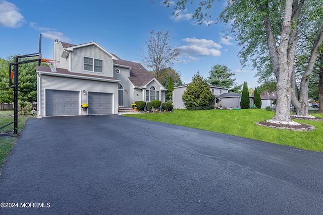 view of front property featuring a front lawn and a garage