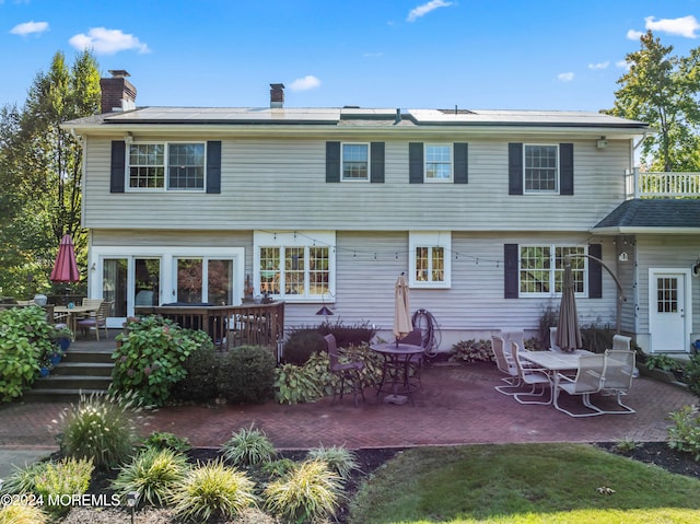 back of property featuring a patio area and a deck