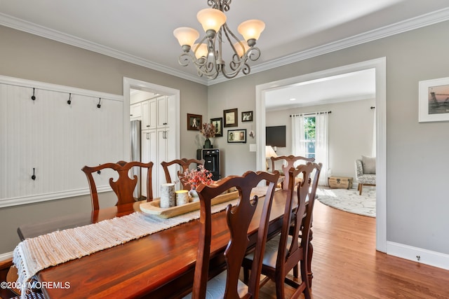 dining room featuring light hardwood / wood-style flooring, ornamental molding, and a chandelier