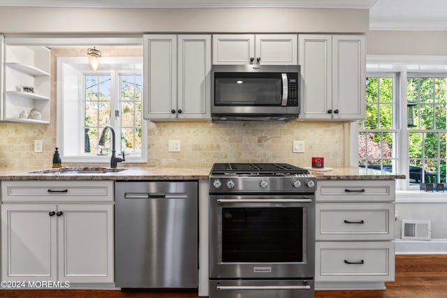 kitchen featuring appliances with stainless steel finishes, white cabinets, sink, and light stone counters