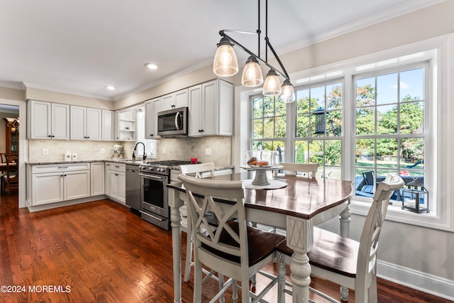 kitchen featuring a wealth of natural light, appliances with stainless steel finishes, pendant lighting, and white cabinetry